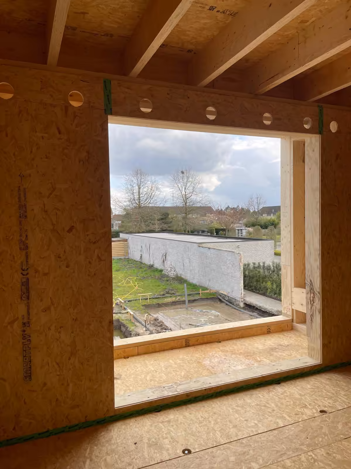 Houten draagstructuur met een groot raamkader op het landschap