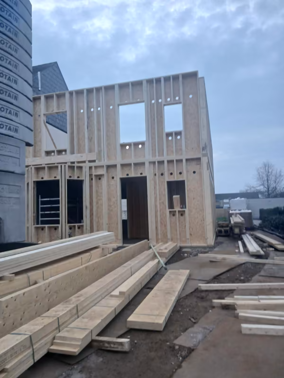 Geprefabriceerde houtelementen worden met een kraan op de werf gemonteerd