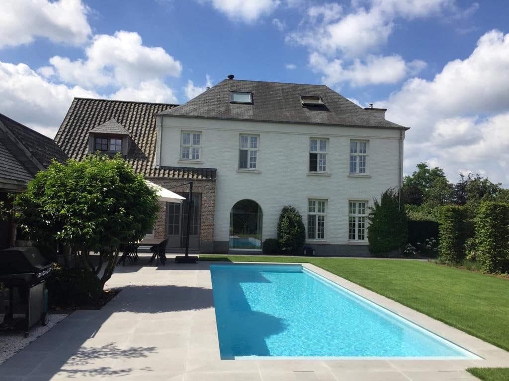 PPC-zwembad in een ruime tuin bij een witte villa